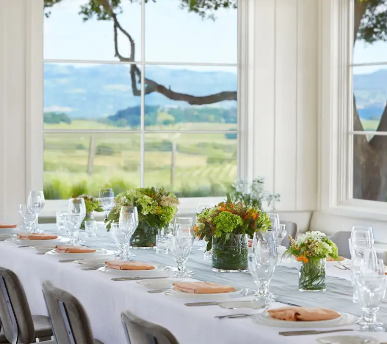 The Hilltop dining room, set for dinner with floor-to-ceiling windows over the valley.