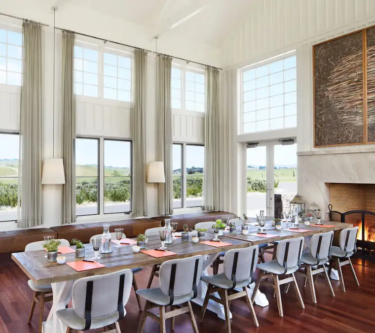 The Hilltop living room: armchairs and sofas around a fireplace, with windows over the valley.